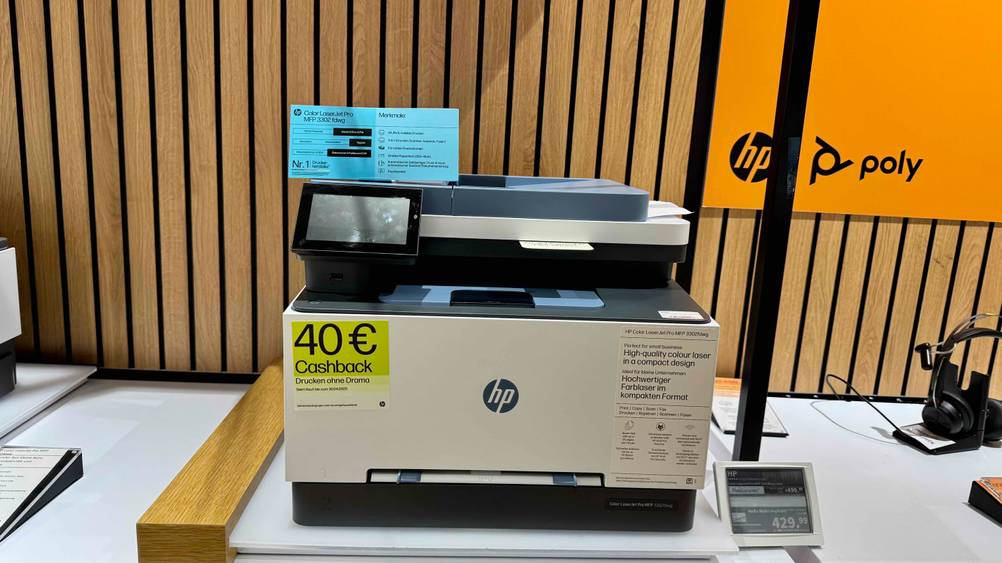 Ein getesteter HP-Laserdrucker von vorne mit Preisangaben daneben.