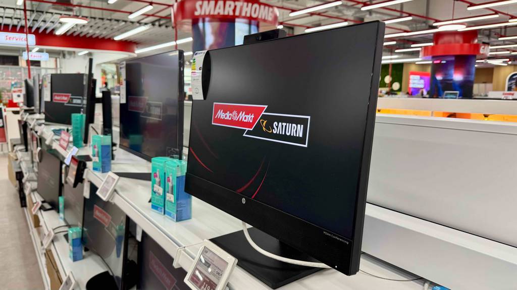 Blick von seitlich rechts auf einen HP-Monitor mit 24 Zoll, der zum testen auf einem weißen Regal steht.