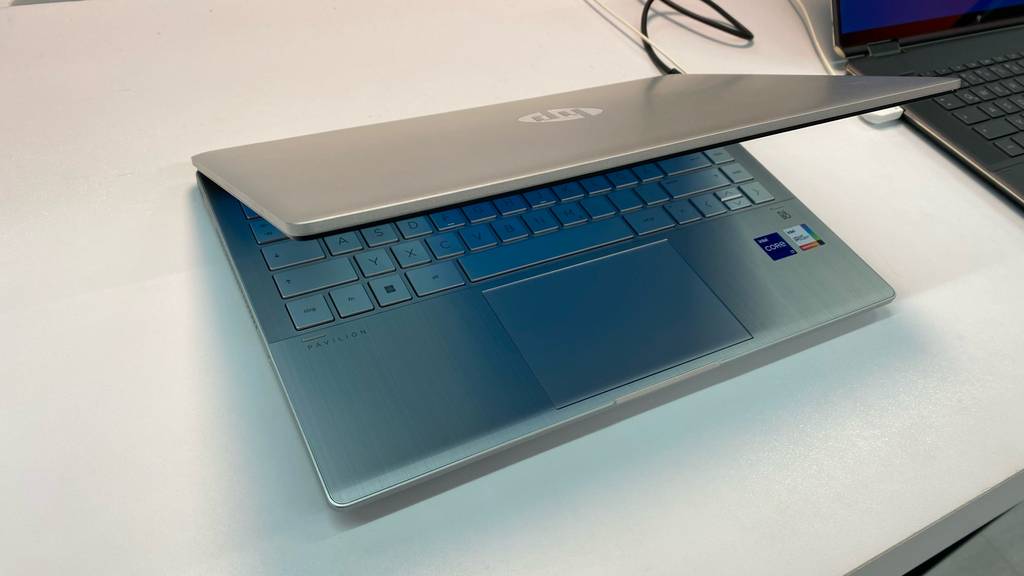 Windows-10-Laptop-Test: eingeschalteter Laptop in Silber befindet sich halb geschlossen neben einem schwarzen Modell in einem Verkaufsbereich.