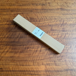 Der Karton des Htly-SPR-Spinnwebenbesens liegt auf einem Tisch.