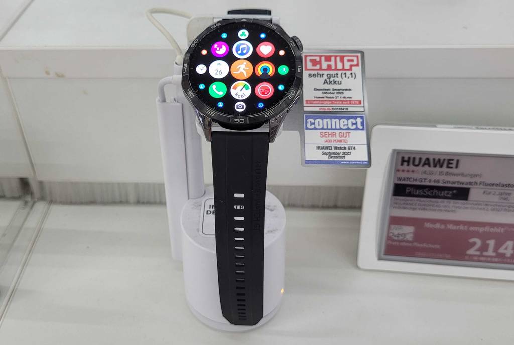 EKG-Uhren im Test: ein HUAWEI-Modell mit schwarzem Armband und rundem Ziffernblatt inklusive App-Ikonen ist auf einem Ausstellungsständer im Geschäft ausgestellt.