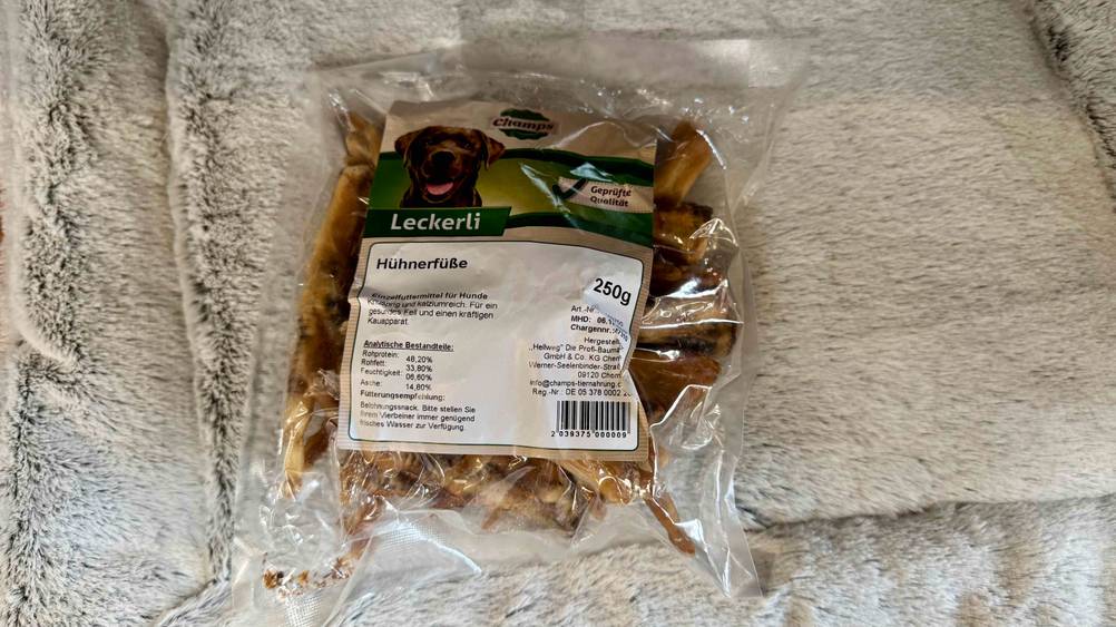 Auf einem hellen Fell liegt eine Packung der gestesteten Hühnerfüße.