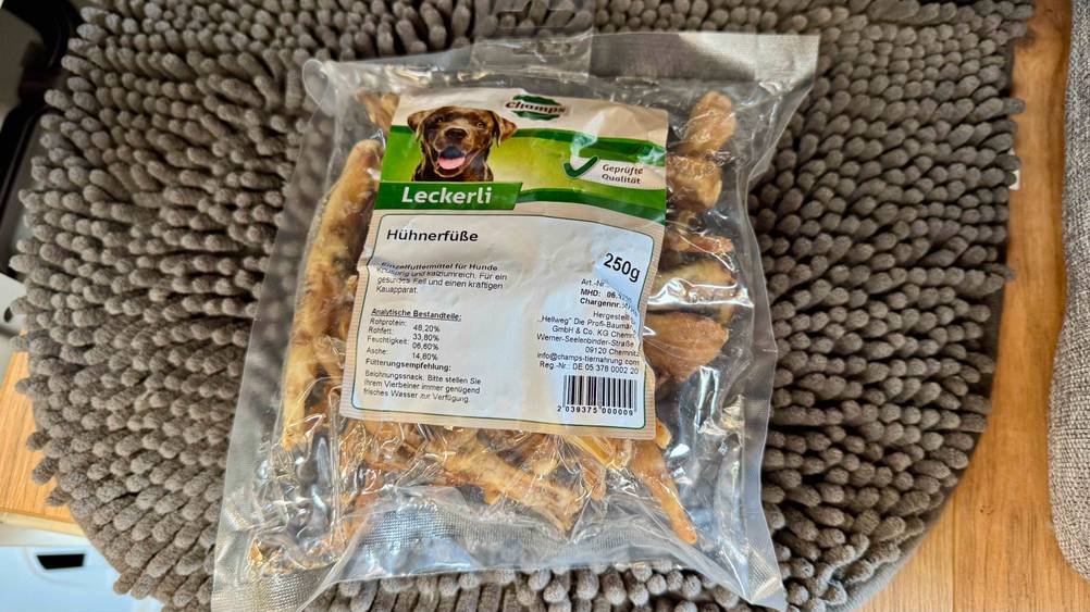 Auf einem grauen Teppich liegt eine Packung der getesteten Hühnerfüße.