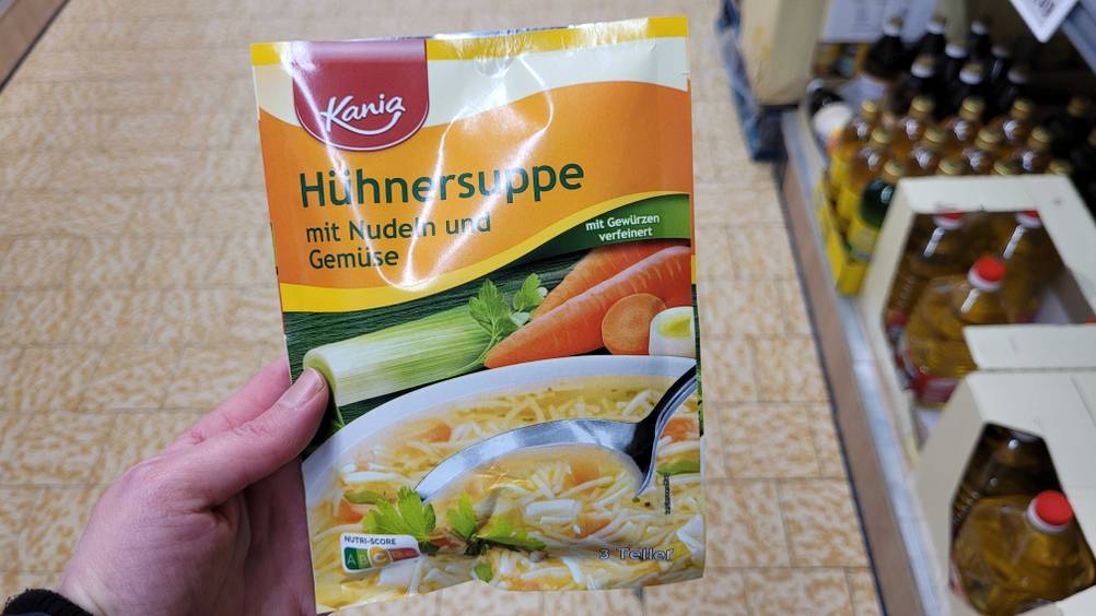 Eine Hand hält eine Packung der Hühnersuppe im Test hoch.