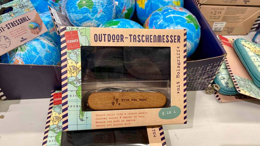 Outdoormesser getestet: Die Origianlverpackung lehnt an einem Karton mit Weltkugeln.
