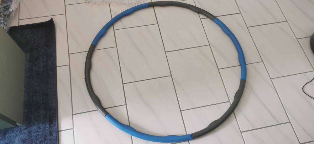 Im Test: Ein Hula-Hoop-Reifen 1,2 kg liegt auf einem Fließenboden.