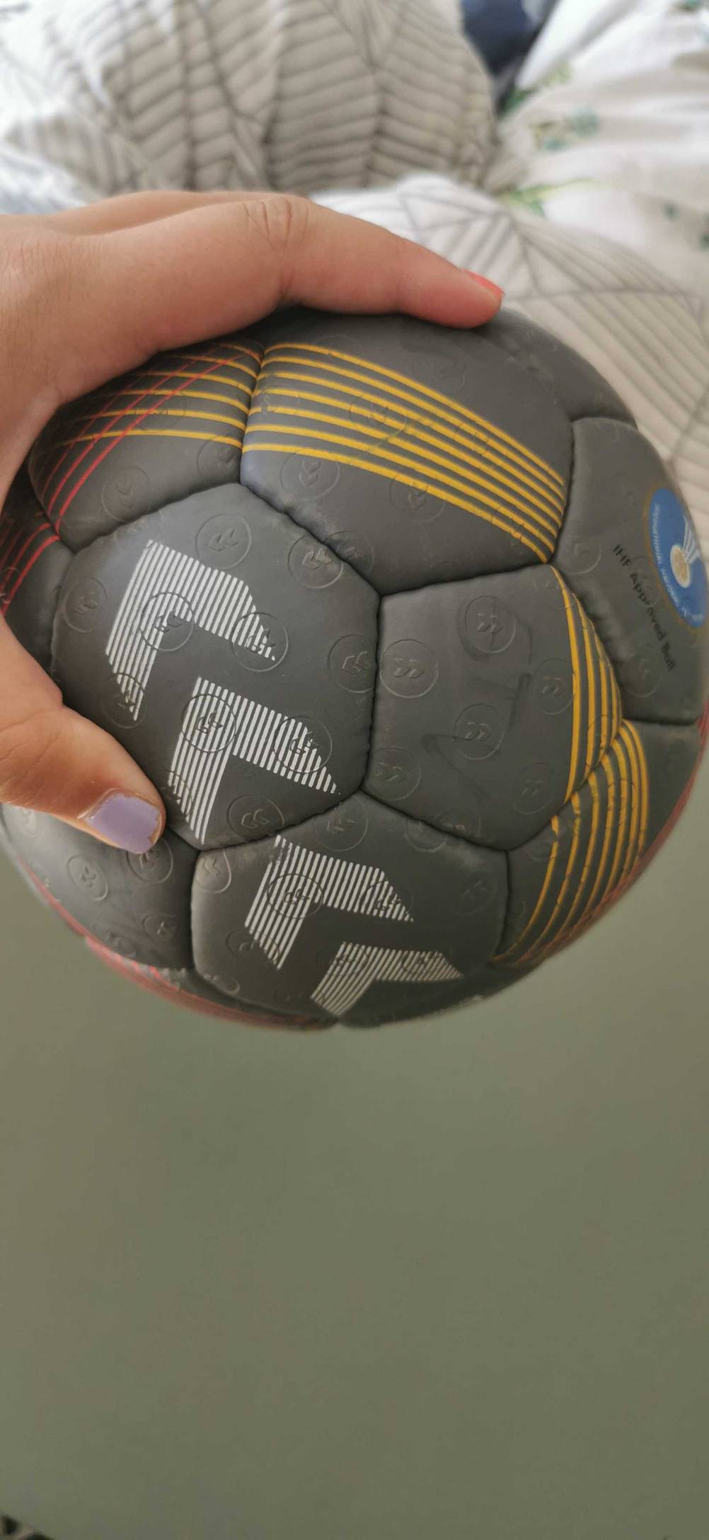 Handball getestet: Nahaufnahme des Musters eines Balles der gehalten wird.