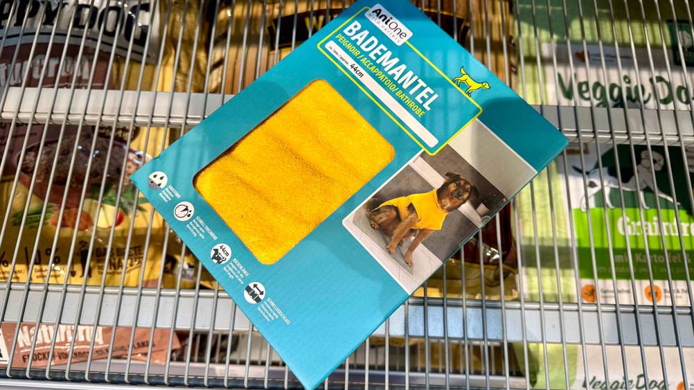 Auf eine Gitter liegt originalverpackt ein Hundebademantel im Test.