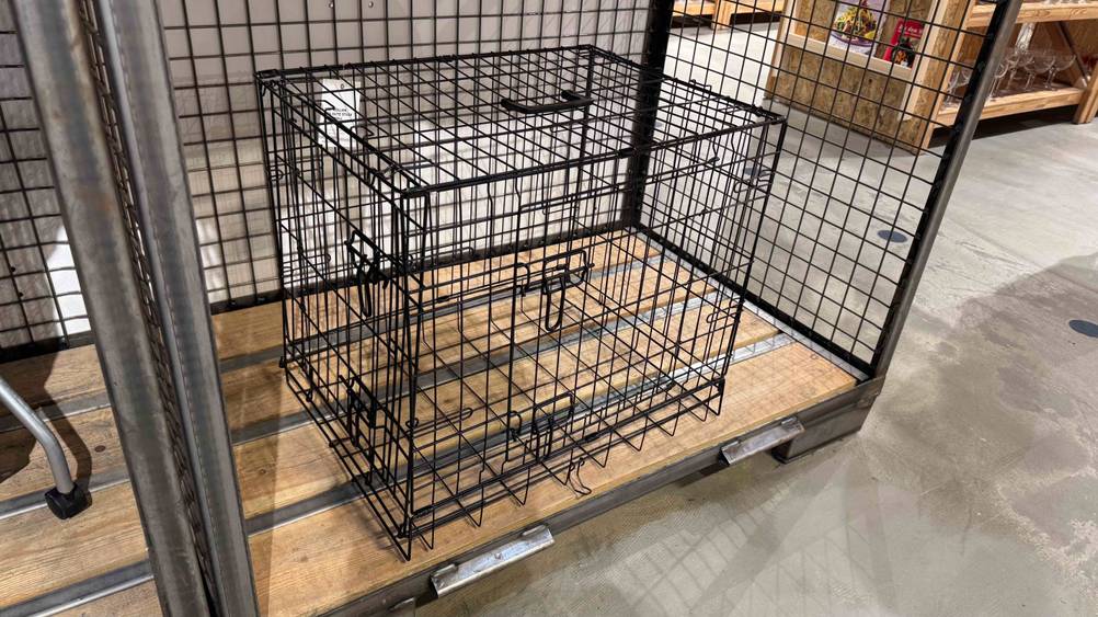 Ein Hundekäfig im Test in einem Regal stehend von vorne.