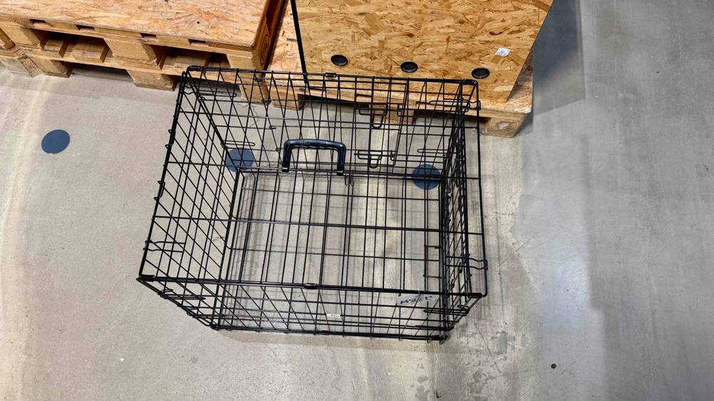 Ein getesteter Hundekäfig von oben auf einem Betonboden stehend.