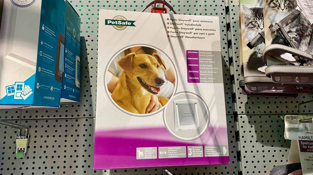 Im Regal eines Geschäftes hängt eine getestete Hundeklappe in einer Verpackung. 