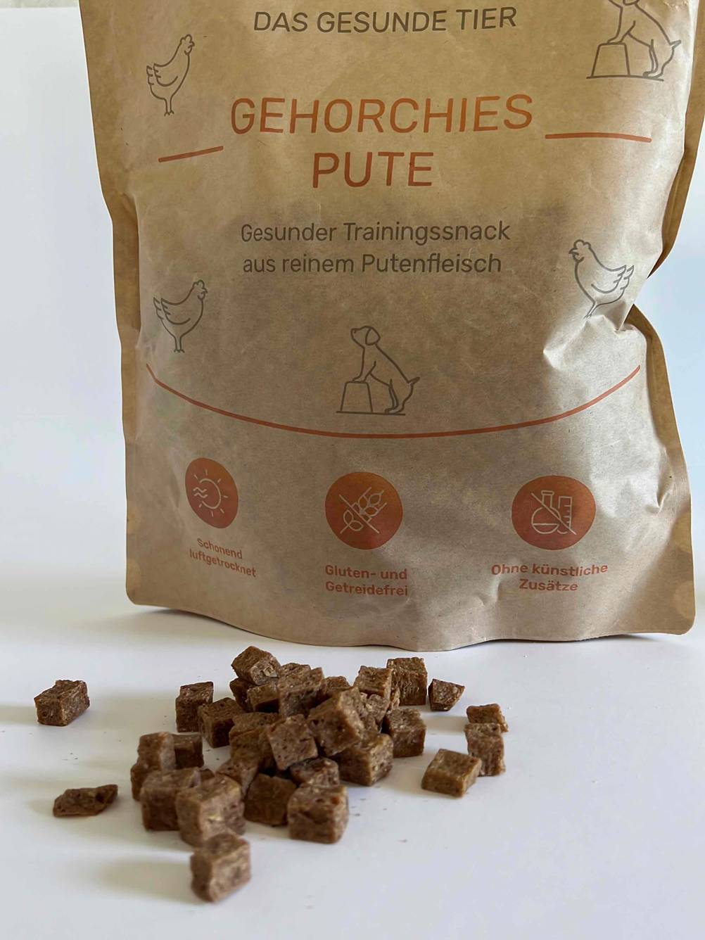 Im Test: Nahaufnahme einiger Hundeleckerlies vor einer Packung auf einer hellen Fläche.