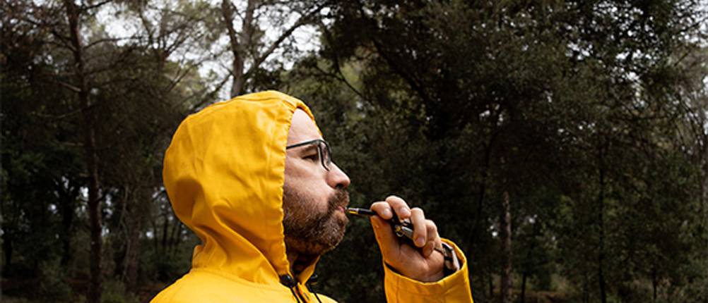 Hundepfeife im Test: Ein Mann in gelber Jacke, der eine Hundepfeife bedient.
