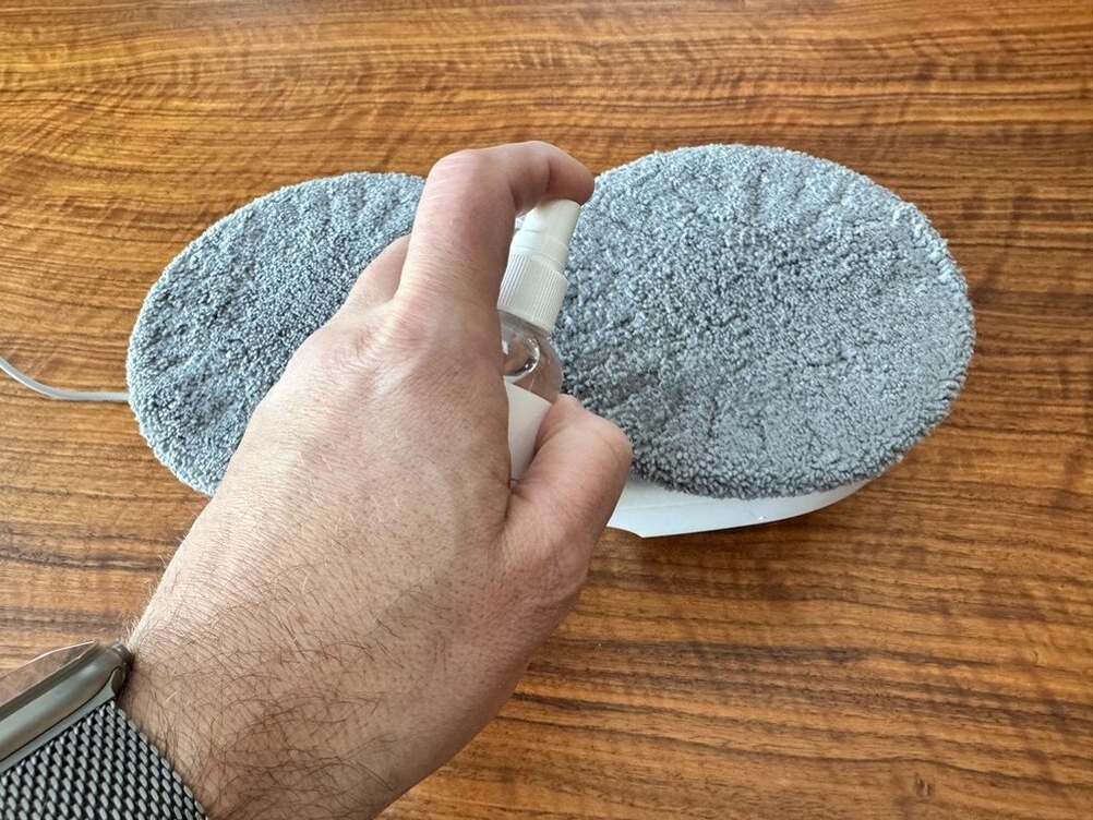 Eine Hand sprüht ein Pad des Hutt DDC55 ein