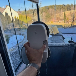 Eine Hand hält den Hutt DDC55 an eine Fenster