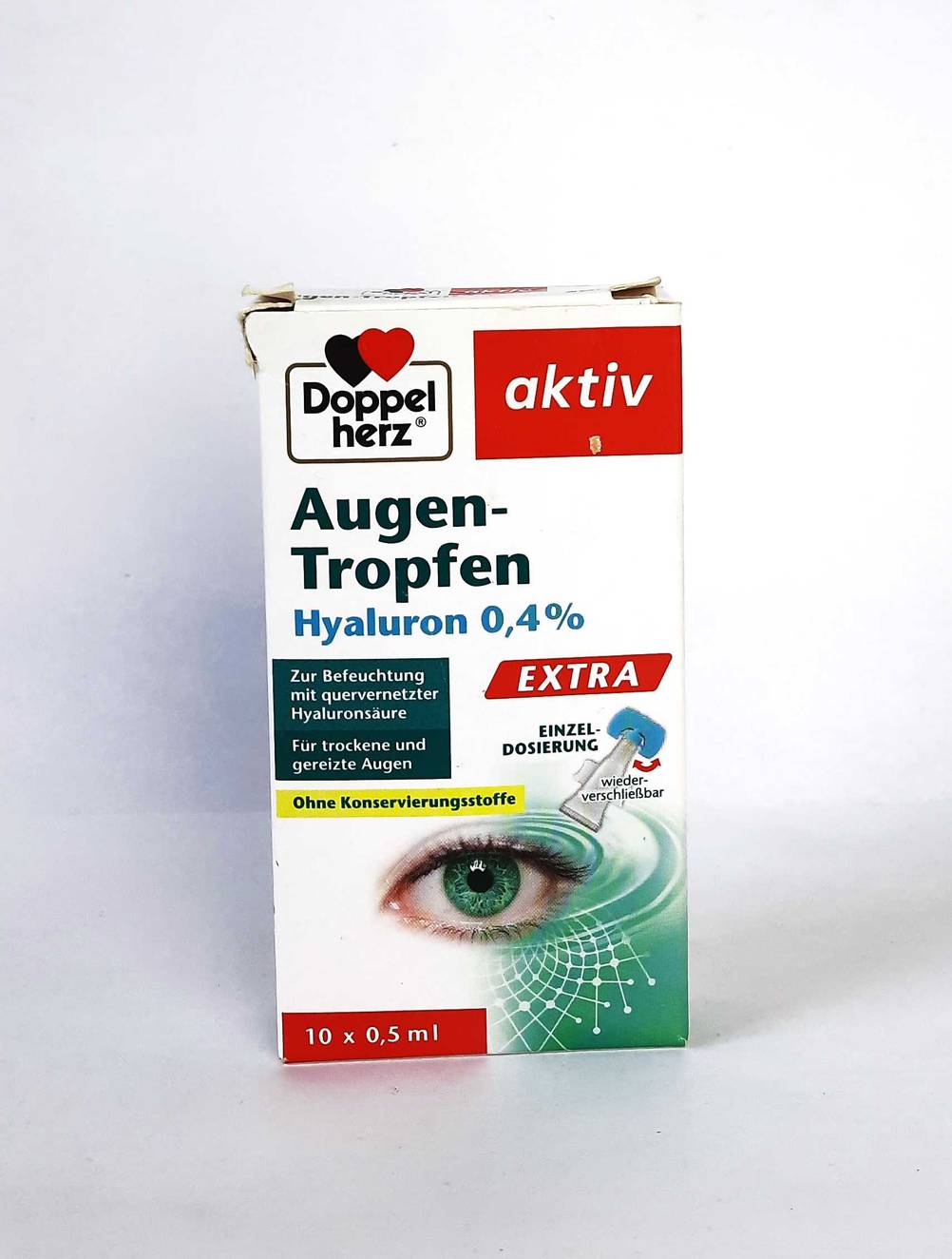 Die Verpackung der Hyaluron-Augentropfen im Test von vorne vor einer hellen Fläche.