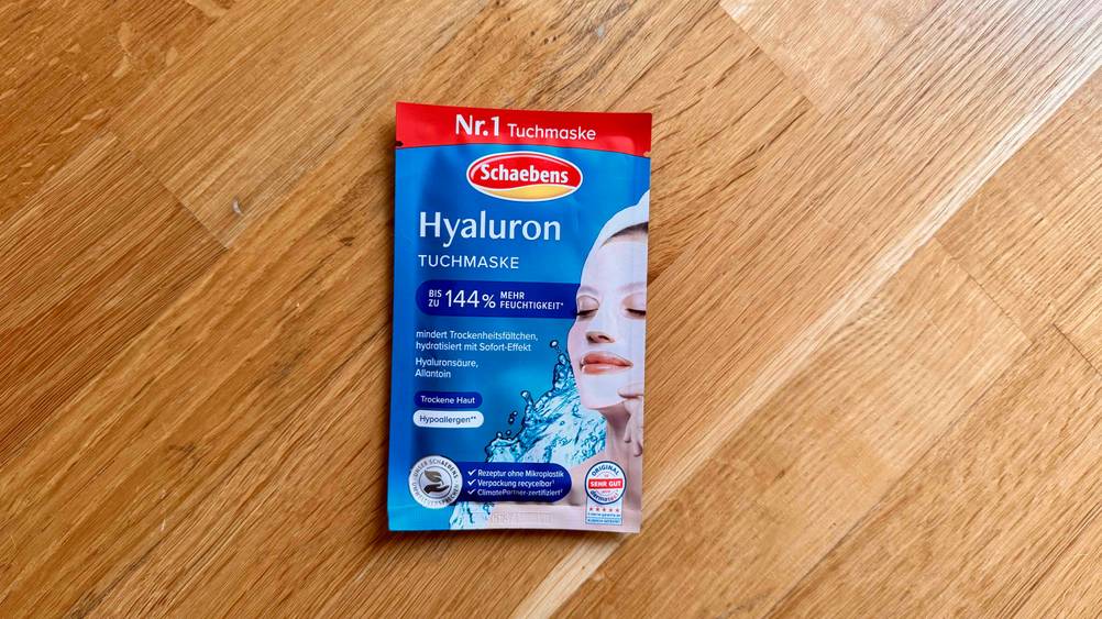 Auf einem Holzboden liegt eine Packung der getesteten Hyaluron-Tuchmaske.