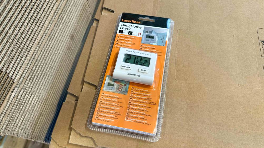 Getestet: Ein Hygrometer in Verpackung liegt auf einem Karton.