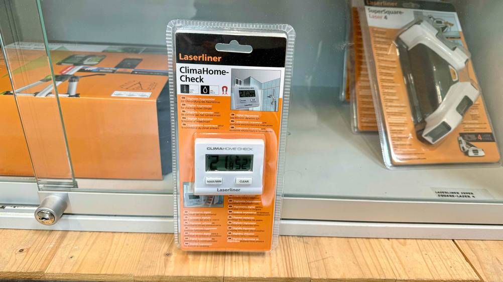 Hygrometer getestet: Ein transparent verpacktes Gerät lehnt an einer Glasvitrine.