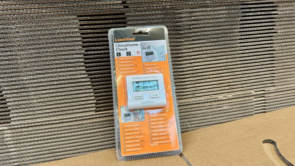 Ein originalverpacktes Hygrometer im Test lehnt an Kartonagen.