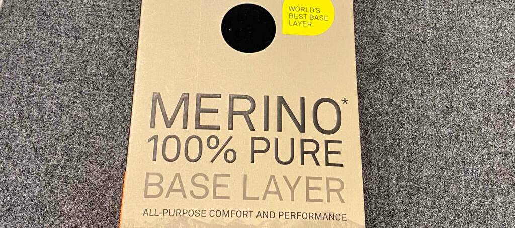 Lange-Unterhose-Herren-Test: Eine getestete lange Unterhosen für Herren aus 100 % Merinowolle in Schwarz liegt innerhalb der Verpackung auf einem grauen Teppich.