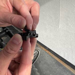 Eine Hand hebt den Gummischutz am Halter des Displays des Icocopro West Biking an