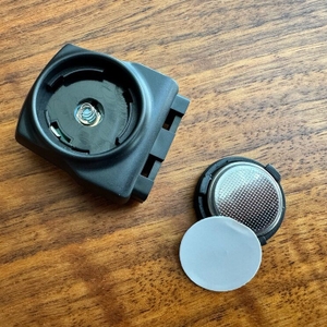 Eine Knopfbatterie liegt neben dem Empfänger des Icocopro West Biking