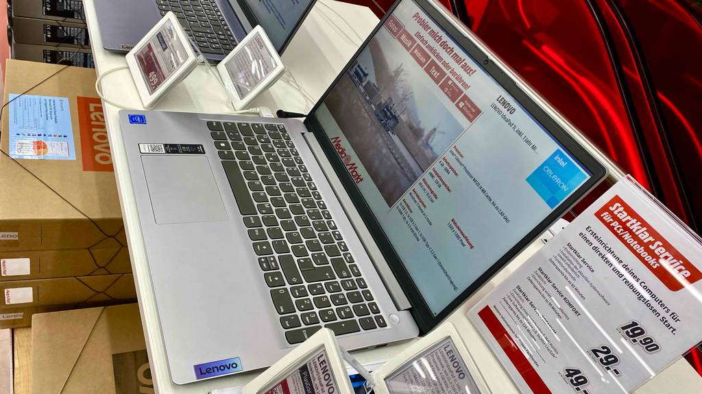 Im Test: Laptop bis 500 Euro in silberfarbigem Design der Marke Lenovo befindet sich geöffnet neben einem Preisschild auf einem Ausstellungsregal mit anderen Laptops.