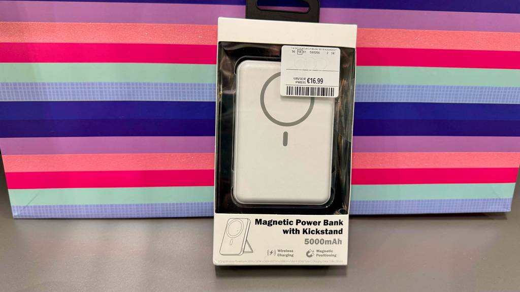 Eine verpackte Powerbank 5000 mAh lehnt zum testen an eine bunt gestreifte Box.