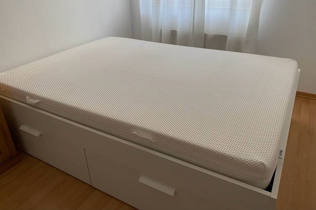Auf einem hellen Bettgestell liegt eine Matratze 160 x 200 cm im Test.
