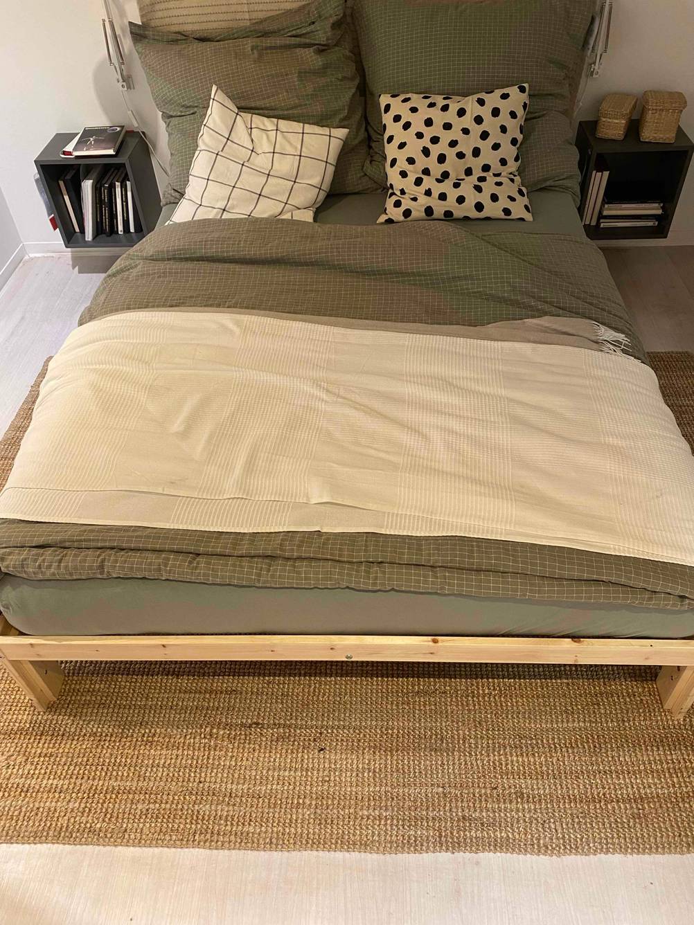 Auf einem beigen Teppich, zwischen zwei Bettkästchen steht ein Bett in 140 x 200 cm im Test.