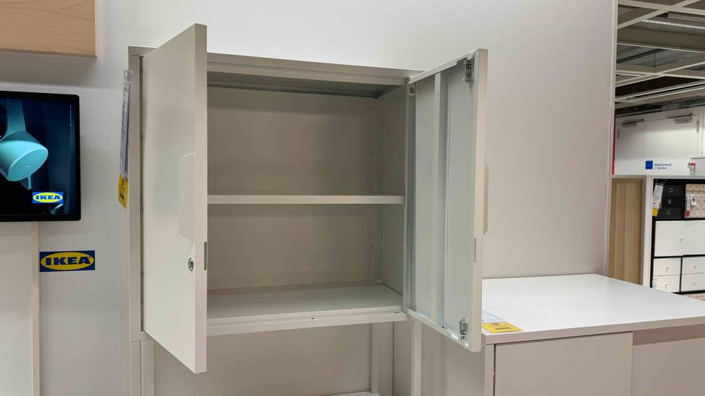 Büroschrank-Test: Nahaufnahme des geöffneten Oberschranks eines weißen Modells von Ikea.