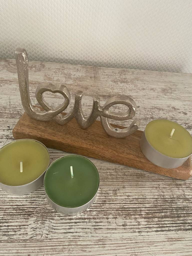 Drei Duft-Teelichter stehen zum testen auf und vor einem Love-Schriftzug.