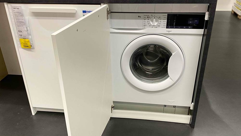 Eine getestete Einbauwaschmaschine in einem Schrank mit geöffneter Türe.