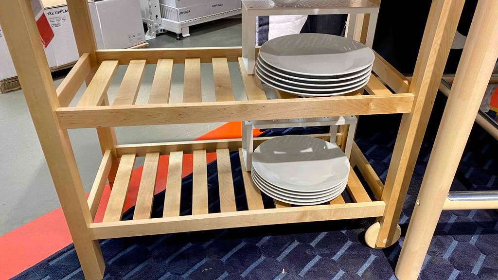 Nahaufnahme eines getesteten Servierwagens von Ikea: fahrbares Modell aus unbehandeltem Holz inklusive Geschirr.