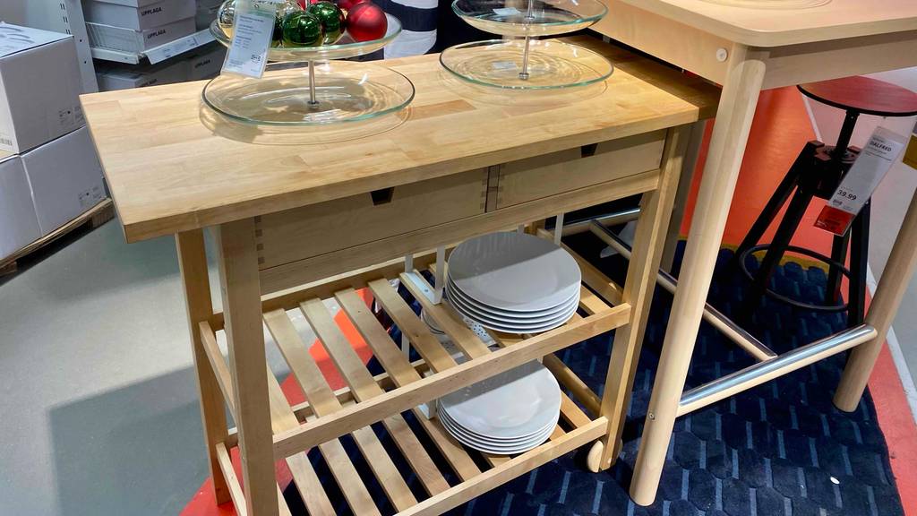 Servierwagen im Test: Ein Ikea-Modell aus unbehandeltem Holz inklusive zweier Ablageflächen und zweier Schubladen steht in einem Verkaufsbereich.
