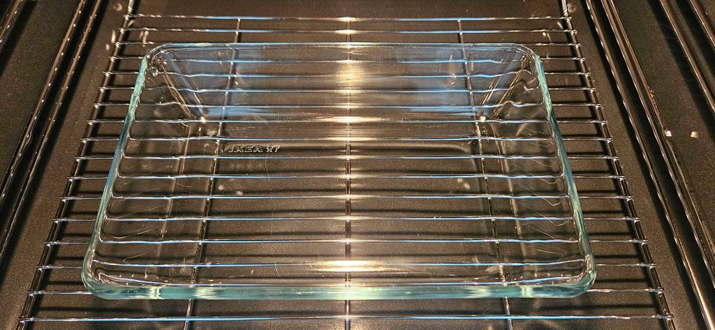 Eine rechteckige getestete Auflaufform aus Glas steht im Backofen.