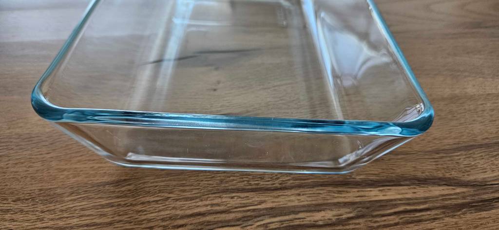 Detailansicht der Dicke des Glases von einer eckigen auf Holz stehenden Auflaufform im Test.
