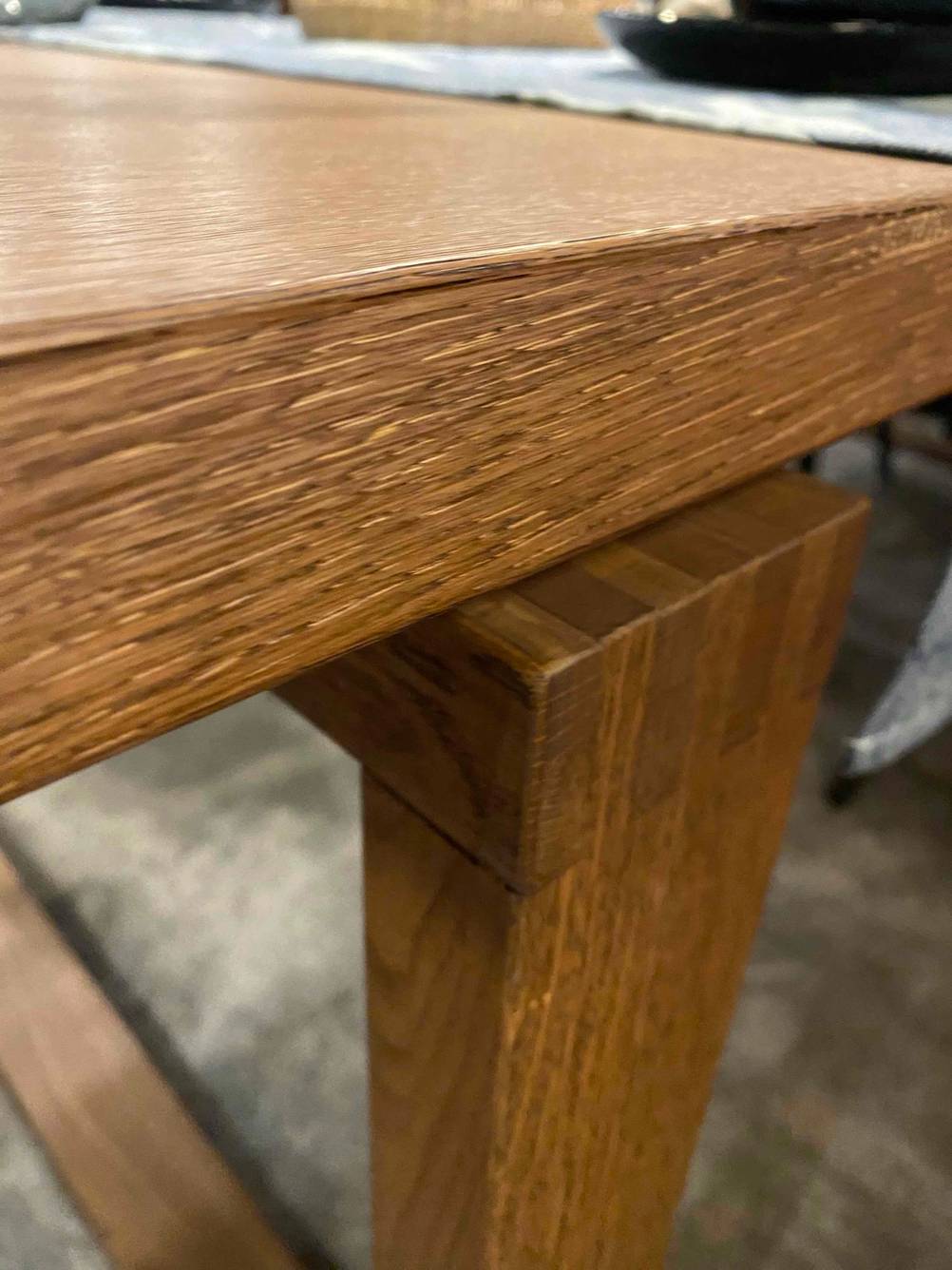Im Test: Nahaufnahme der Verbindung von Tischplatte und Tischbein eines Esstisches aus Holz.