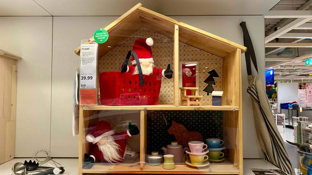 Ein getestetes Puppenhaus von vorne auf einem Regal vor einer hellen Fläche.