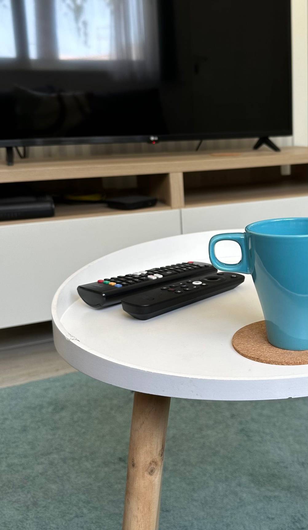 Getestet: Auf einem Beistelltisch liegen zwei Fernbedienungen hinter einer Kaffeetasse.