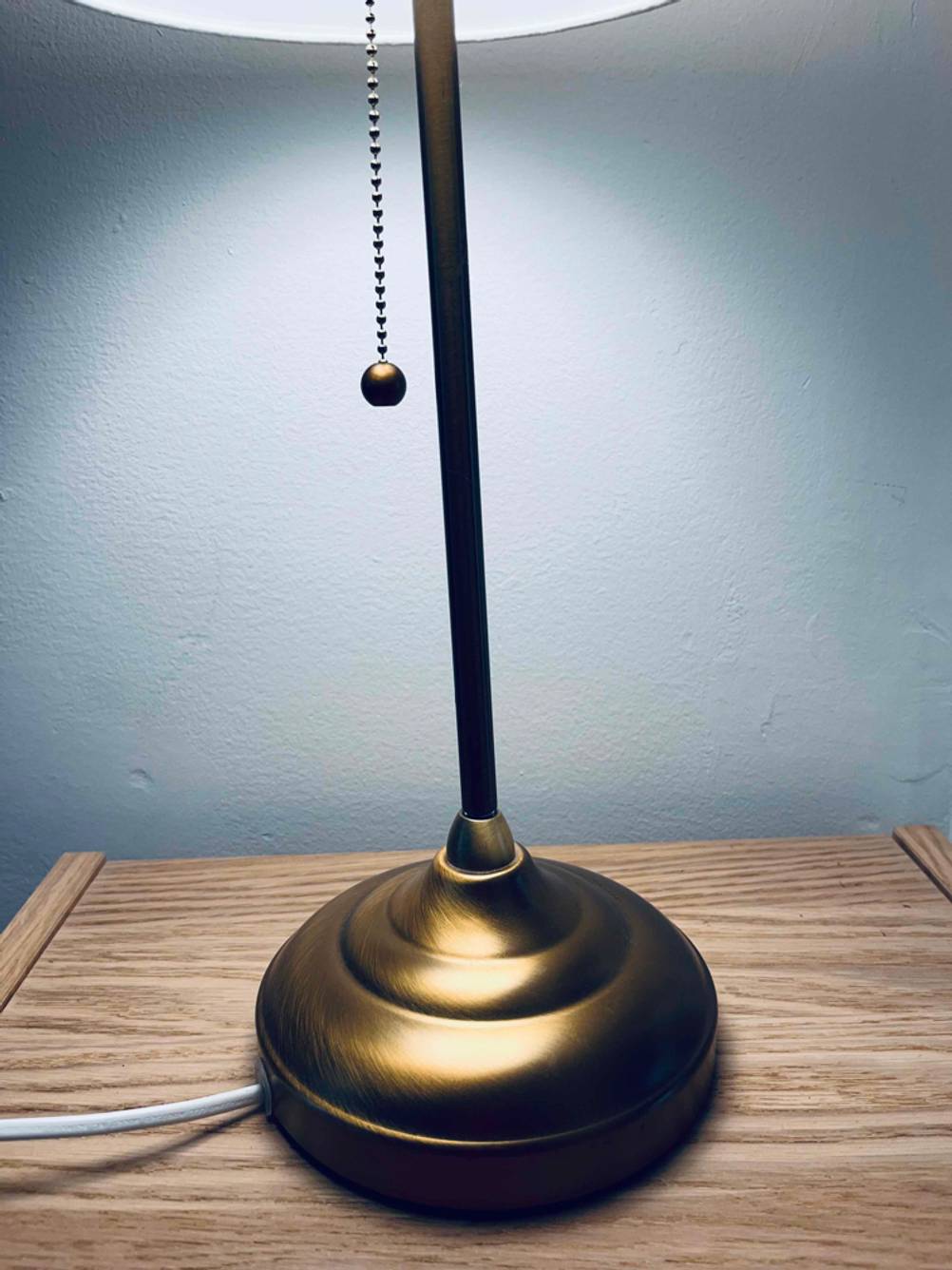 Schreibtischlampe getestet: Standfuss in Nahaufnahme auf einer Holzfläche.