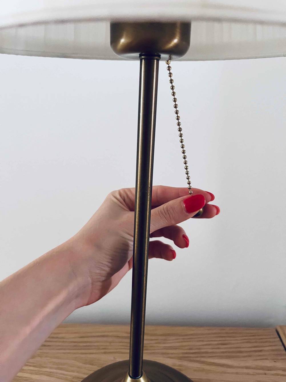 Im Test: Eine Hand betätigt den Zug einer Schreibtischlampe.