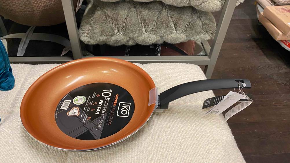 Pfanne 26 cm getestet: Eine Pfanne steht auf einer hellen Oberfläche vor einem Regal.