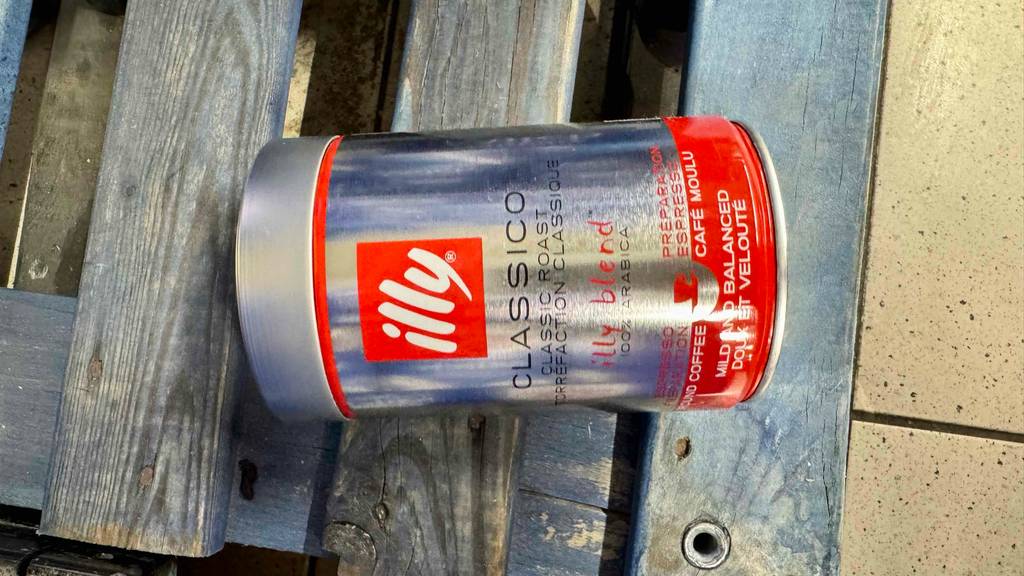 Eine Dose getesteter Illy-Kaffee liegt quer auf einer blauen Palette.