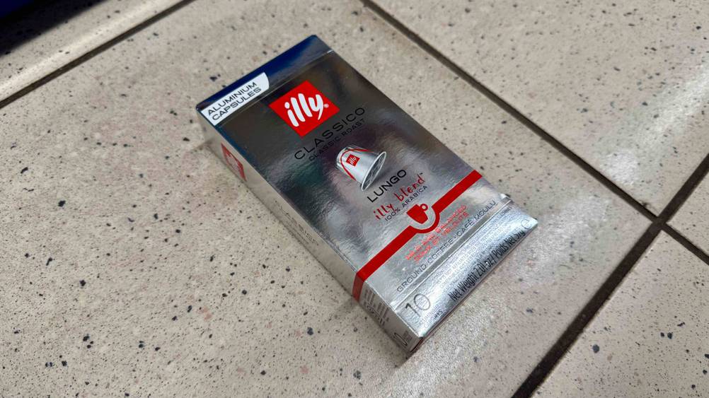 Auf einem Fließenboden liegen die illy-Kapseln im Test in der Originalverpackung.