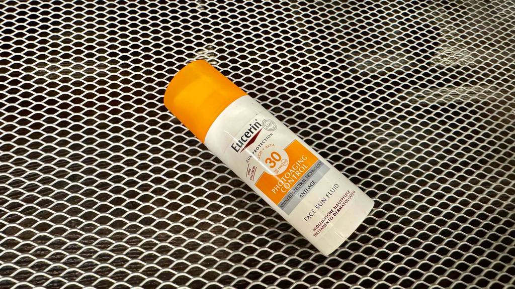 Getestet: Eine Eucerin-Sonnencreme mit Lichtschutzfaktor 30 liegt in der Kunststoffflasche auf einem Gitteruntergrund.