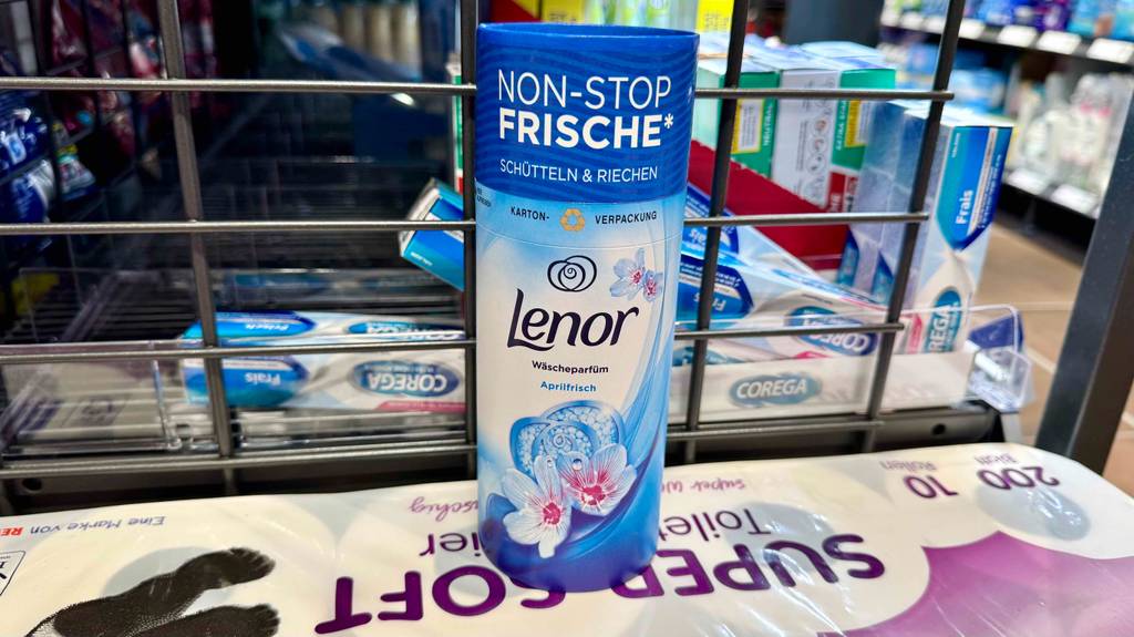 Im Test: Ein Lenor-Wäscheparfüm in der Karton-Verpackung steht in einem Drogeriemarkt auf einer Packung Toilettenpapier.