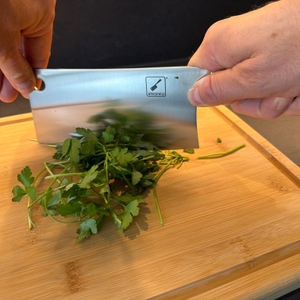 Zwei Hände zerkleinern Petersilie mit dem imarku-Küchenmesser