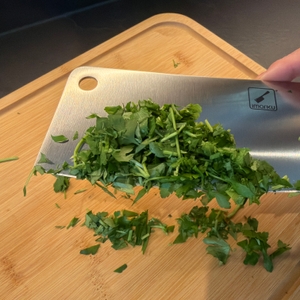 Zerkleinerte Petersilie hängt am imarku-Küchenmesser